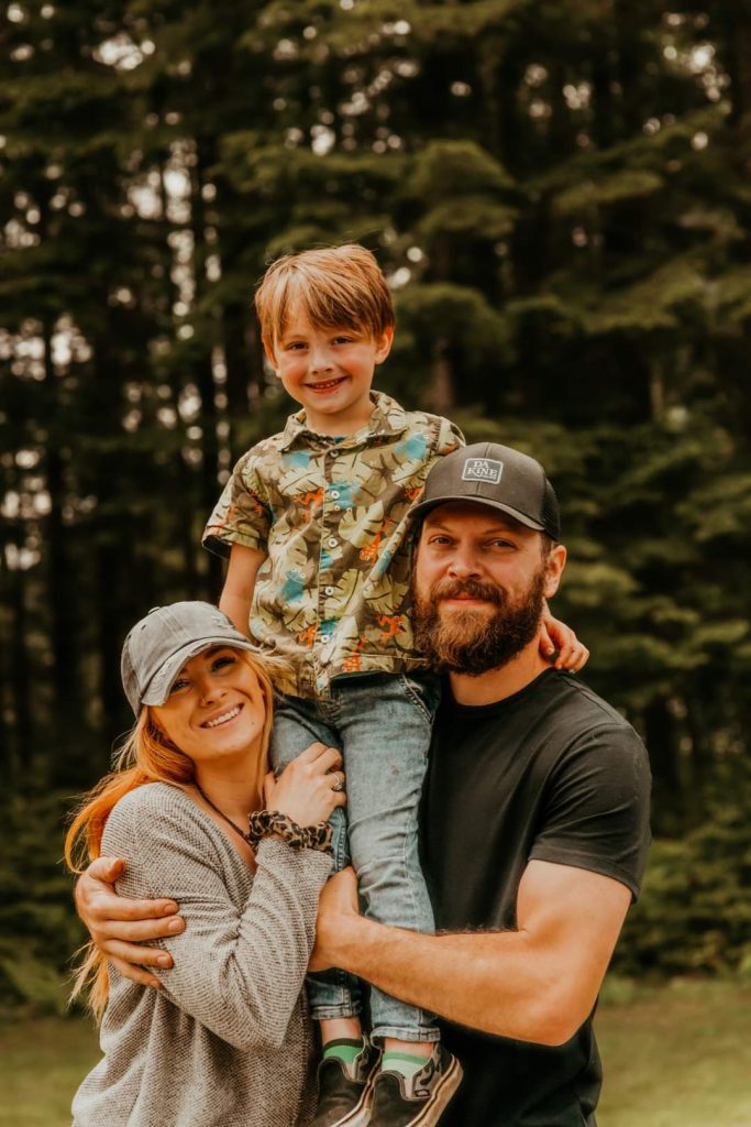 A mother and father lifting their son into the air