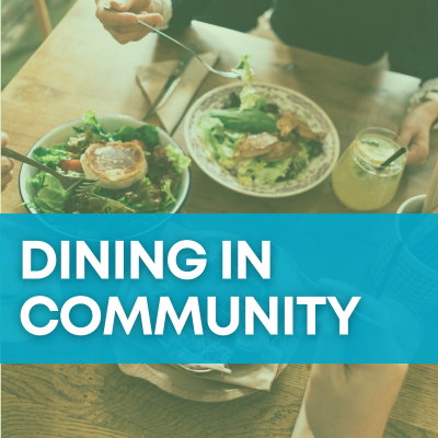 A teal banner with white text that says "Dining in Community" sits over a background image of people eating garden-fresh salad at a cheery community table.