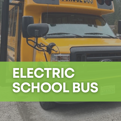 A photo of the East Whatcom Regional Resource Center's new electric school bus, with a bright green banner