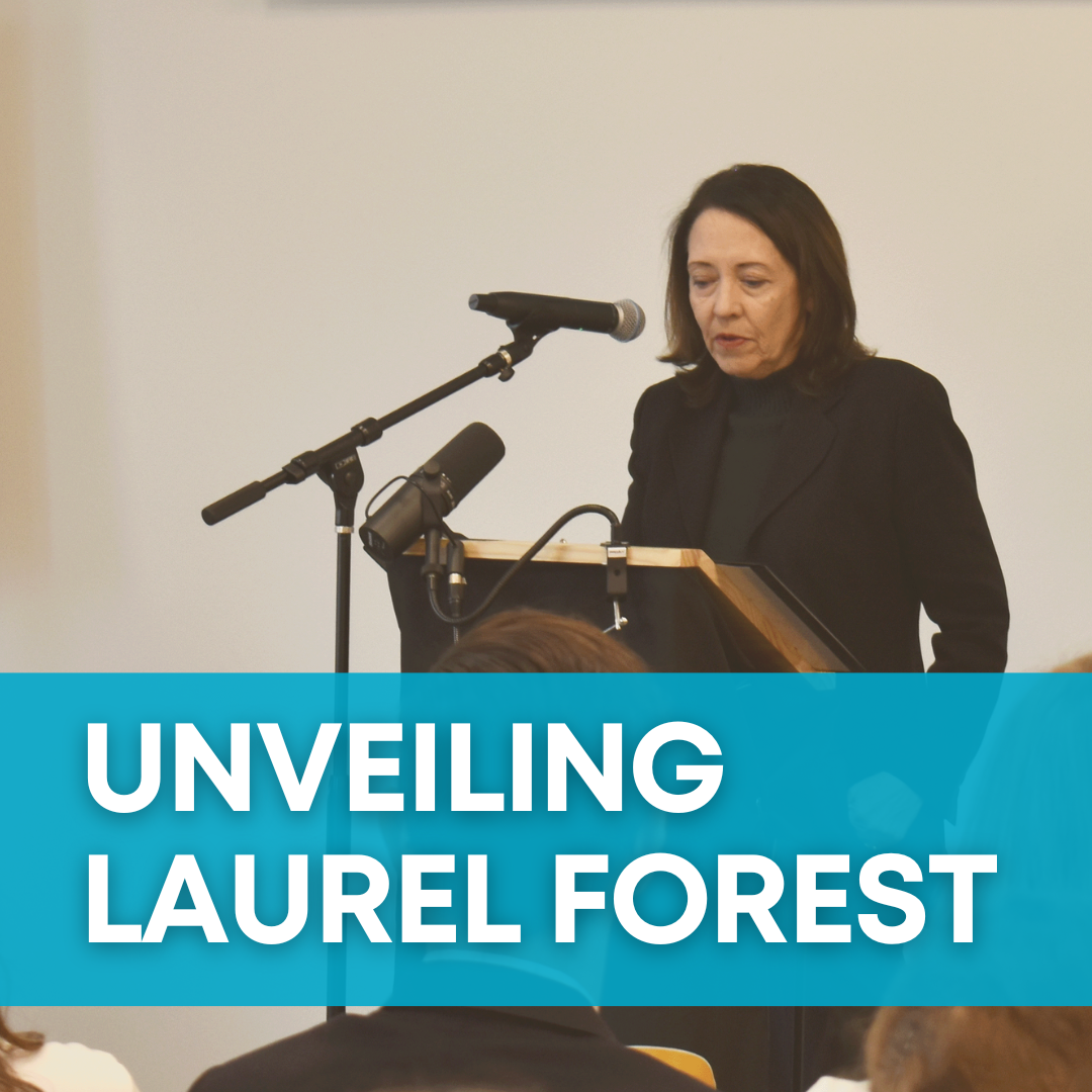 A woman, US Senator Maria Cantwell, speaks behind a podium. A teal banner behind the photo says "Unveiling Laurel Forest."