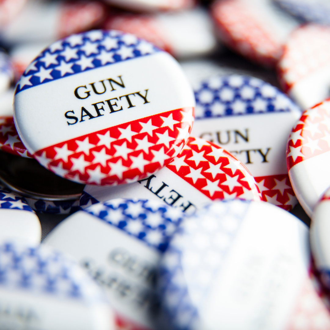 A pile of campaign buttons that read "GUN SAFETY" in black against a white background.