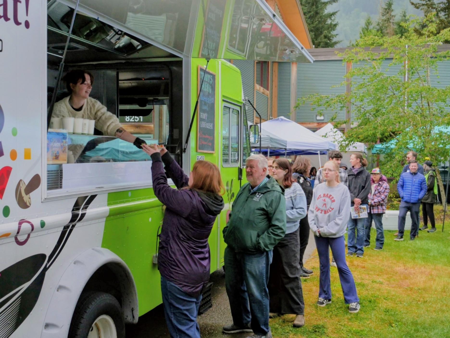 People line up and receive food at the Common Threads Food Truck