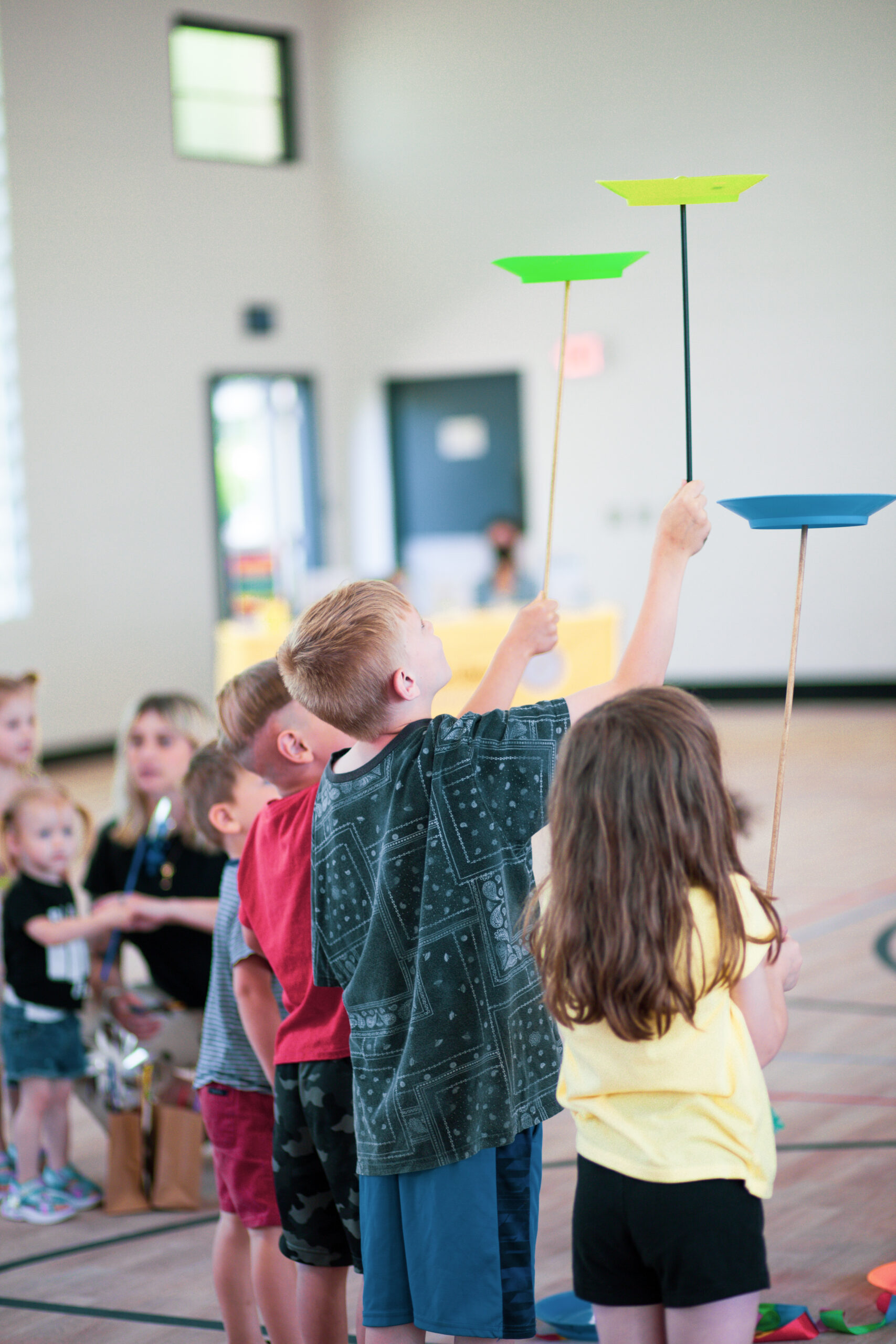 Kids balance Frisbees on sticks